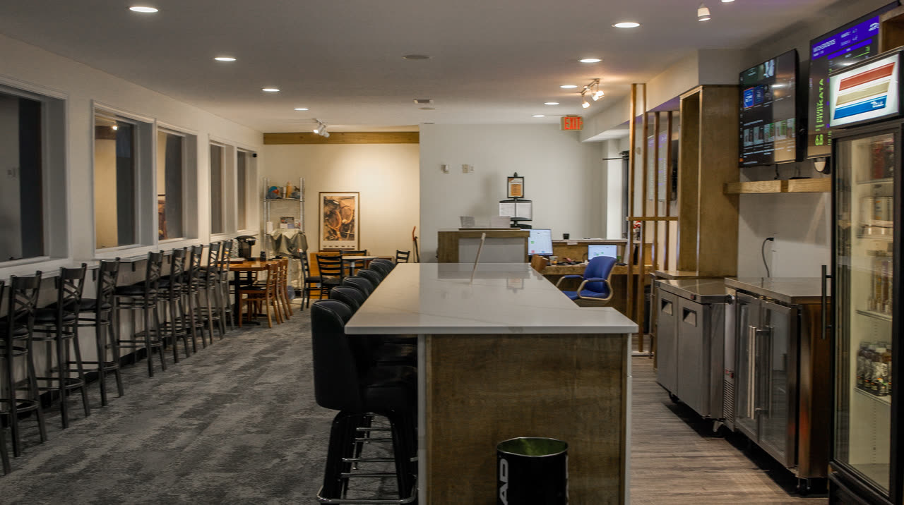 The lounge counter, TVs and drink fridges at Match Point KC